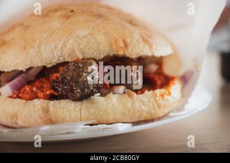 Gros plan du plat de Cevevi servi sur une assiette. Cuisine traditionnelle des balkans, viande hachée en petites saucisses servie dans un petit pain avec oignons et ajvar sau Banque D'Images