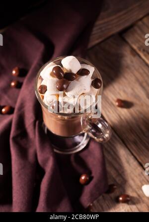 Chocolat chaud avec cannelle et guimauve sur fond de bois avec bonbons au chocolat Banque D'Images