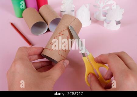 Comment faire des arbres, décoration. Activités quotidiennes, bricolage pour enfants, zéro déchet, jouets écologiques fabriqués à la main à partir d'un rouleau de papier. 3 étapes prendre des ciseaux. Banque D'Images