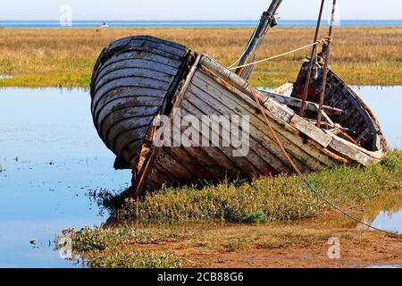 Gros plan d'un bateau de pêche traditionnel en bois qui se détériore hors de l'eau au port de North Norfolk à Thornham Norfolk, Angleterre, Royaume-Uni. Banque D'Images