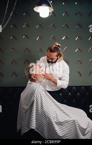 jeune coiffeur créatif faisant son travail au salon de beauté, gros plan vue de côté photo. guy créateur de beauté, de mode, de style Banque D'Images