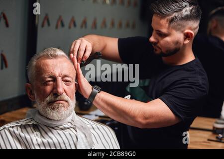 secrets de la coupe de cheveux tendance..beau vieux homme obtenant ses cheveux fait. gros plan photo, profession, travail Banque D'Images