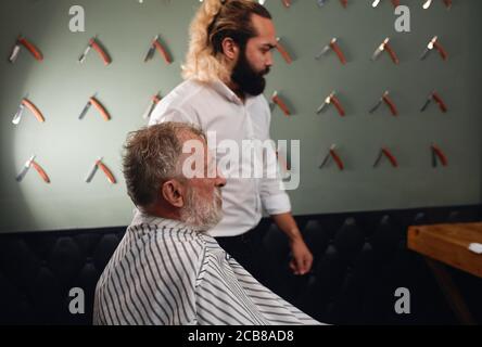 Old barber assis au salon de coiffure, gros plan portrait de vue latérale, l'homme se prépare à couper son Hait.style de vie, temps libre, temps libre Banque D'Images