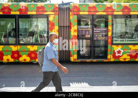 France - Montpellier - 11 août 2020 - Homme portant un masque de visage marchant le long d'un tramway à Montpellier - photographe : Brian Duffy Banque D'Images