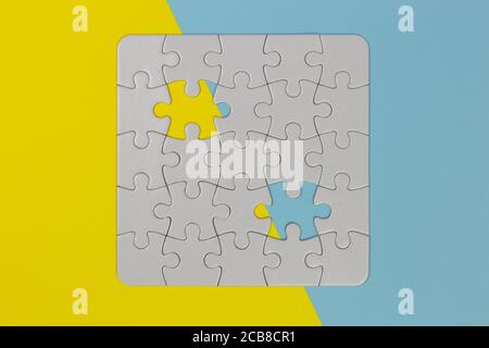 puzzle vierge sur la surface jaune et bleue à deux tons, vue de dessus Banque D'Images