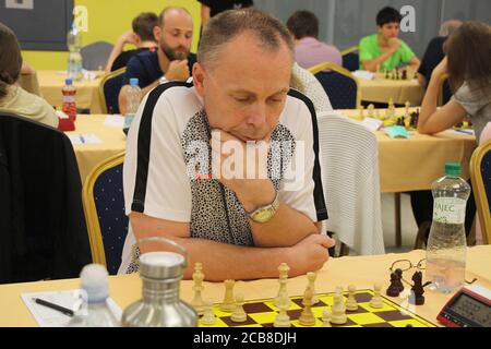 Un joueur tchèque d'âge moyen d'échecs attaque son menton alors qu'il réfléchit dur à son jeu d'échecs lors du Czech Tour 2020 à Prague. Banque D'Images