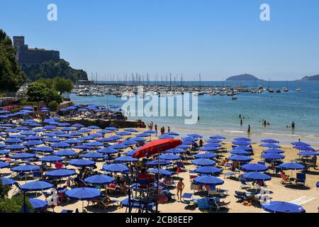 Vue panoramique sur la plage de sable sur la rive du golfe des Poets avec le port, le château et l'île de Tino en arrière-plan, Lerici, italie Banque D'Images