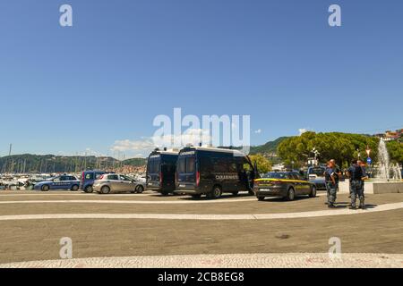 Des véhicules de police italiens et un groupe de policiers attendent l'arrivée du politicien Matteo Salvini pour un rassemblement dans la ville maritime de Lerici, en Italie Banque D'Images