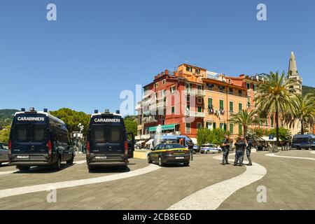 Des véhicules de police italiens et un groupe de policiers attendent l'arrivée du politicien Matteo Salvini pour un rassemblement dans la ville maritime de Lerici, en Italie Banque D'Images