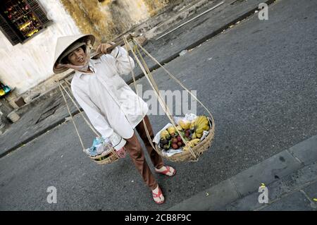 Femme portant des paniers de fruits à Hoi an, Vietnam Banque D'Images