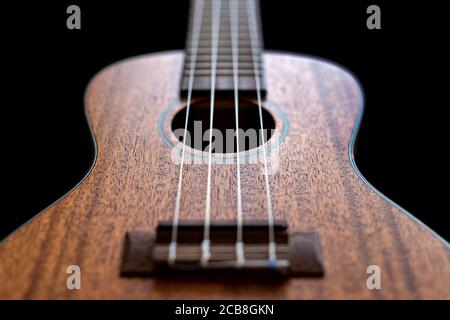 Vue rapprochée d'un corps en bois d'ukulele isolé sur fond noir. Banque D'Images