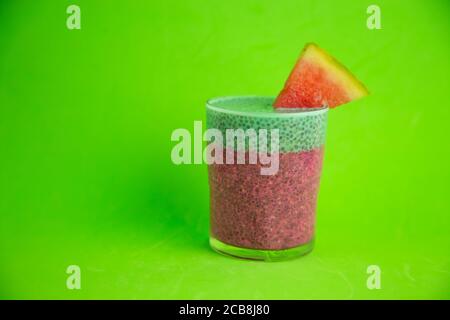 Gros plan d'un verre de gâteau de chia noir avec goût de pastèque sur fond vert Banque D'Images