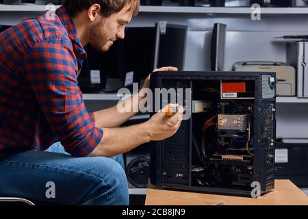 jeune homme talentueux rassemblant l'unité du système, gros plan vue latérale photo. espace de copie Banque D'Images