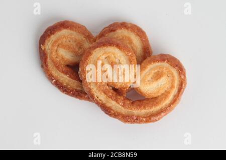 Prise de vue en grand angle de deux morceaux de pain en forme de bretzel isolés sur une surface blanche Banque D'Images