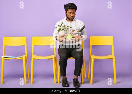 Portrait d'un jeune triste homme à la peau sombre tenant une boîte de personnel les effets personnels sont tirés du travail Banque D'Images