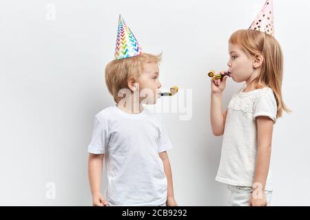 enfants séduisants célébrant leur anniversaire, sentiment positif et émotion, portrait de près, arrière-plan blanc isolé, prise de vue en studio Banque D'Images