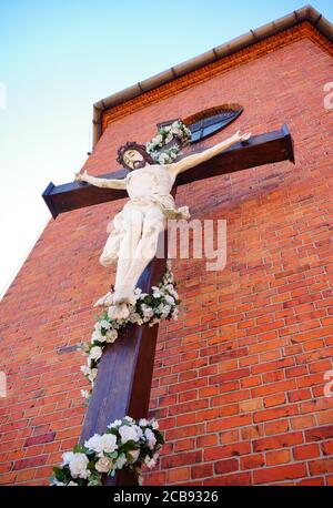 Photo à angle bas de la crucifixion dans un bâtiment de mur de briques Banque D'Images