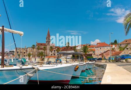 Belle vue panoramique pittoresque d'une petite ville de Milna sur l'île de Brac. Vieux bateaux amarrés dans la mer cristalline, chaude journée d'été. Ancien c Banque D'Images