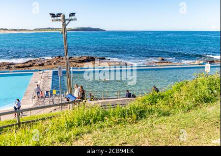 Dee Why Rockpool et long Reef Headland arrière-plan Blur On un après-midi d'automne ensoleillé avec ciel bleu et eaux turquoise Banque D'Images