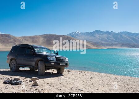 Montagnes de Pamir, Tadjikistan - Toyota Land Cruiser est arrêté sur le lac Yashilkul à Gorno-Badakhshan, Tadjikistan. Banque D'Images