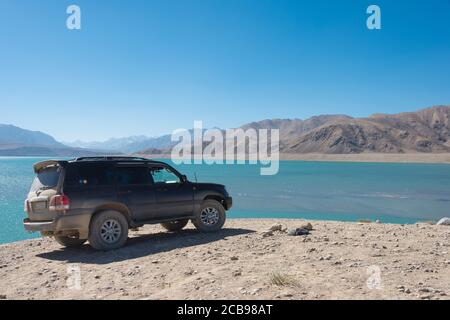 Montagnes de Pamir, Tadjikistan - Toyota Land Cruiser est arrêté sur le lac Yashilkul à Gorno-Badakhshan, Tadjikistan. Banque D'Images