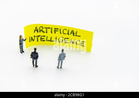Réunion de présentation avec des figurines miniatures posées comme des hommes d'affaires debout En face de post-it note avec l'intelligence artificielle mess manuscrit Banque D'Images