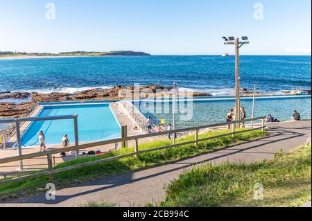 Dee Why Rockpool et long Reef Headland arrière-plan Blur On un après-midi d'automne ensoleillé avec ciel bleu et eaux turquoise Banque D'Images