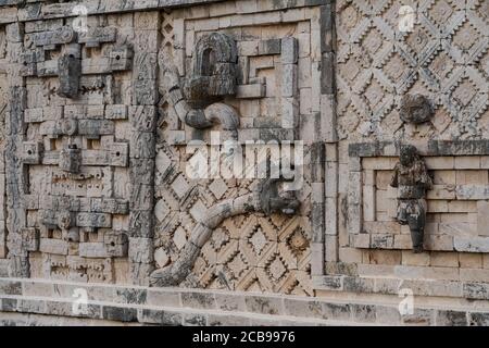 La tête et la queue du crotale géante à plumes qui Le long du bâtiment ouest dans le Nunnery Complexe dans les ruines mayas pré-hispaniques Banque D'Images