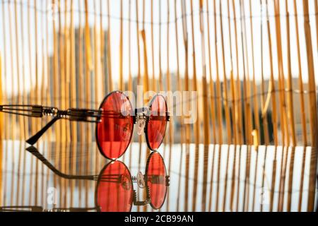 Lunettes de soleil steampunk avec lentille ronde rouge rester sur la table pendant une journée ensoleillée en été. Mise au point sélective Banque D'Images