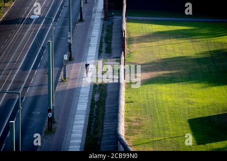 Berlin, Allemagne. 11 août 2020. Un jogging court le matin sur la Bernauer Strasse le long du mur de Berlin. Il y a 59 ans, le 13 août 1961, la construction du mur commença, qui divisa Berlin pendant plus de 28 ans. Credit: Christoph Soeder/dpa/Alay Live News Banque D'Images