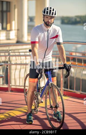 Homme sérieux en vêtements de sport et casque à vélo Banque D'Images