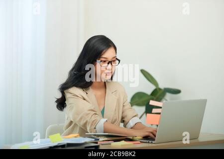 Tête de tir agréable bonne jeune femme freelance travaillant sur ordinateur à la maison. Banque D'Images