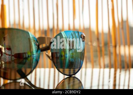 Des lunettes de soleil avec lentille bleue reflètent le soleil. Modèle œil de chat pour femme en gros plan. Mise au point sélective Banque D'Images