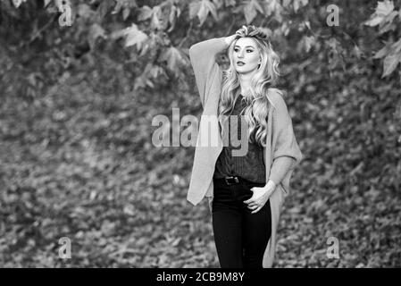 Tenues décontractées confortable pour la fin de l'automne. Adorable petite fille blonde posing in outfit chaleureux et cosy de l'automne nature fond flou. Création pour agréable fin de semaine. Femme à pied. La lumière au coucher du soleil Tenue confortable. Banque D'Images