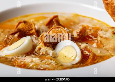 Soupe en gros plan avec chanterelles et légumes et croûtons frits. Recette délicieuse avec champignons sauvages, légumes biologiques et œufs de caille. Banque D'Images