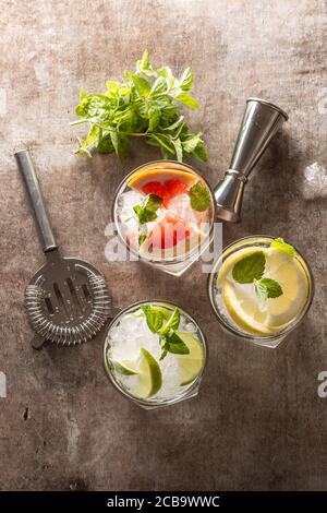 Trois cocktails toniques de gin colorés dans des verres à whisky au bar comptoir dans le restaurant ou le chiot Banque D'Images