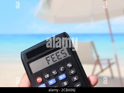 Calculatrice avec le mot FRAIS sur l'affichage paysage de plage . Concept de taxes Banque D'Images