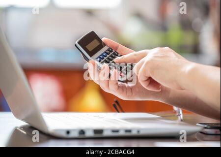 concept de commerce électronique. Main de la personne qui tient la calculatrice et qui saisit les données. Banque D'Images