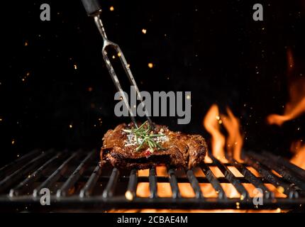 Fiery grill grille avec morceau de steak de boeuf. Espace libre pour le texte Banque D'Images