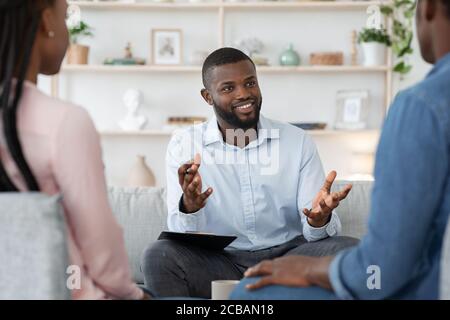 Conseiller en famille noire confiant parlant avec un couple marié, donnant des conseils aux conjoints Banque D'Images