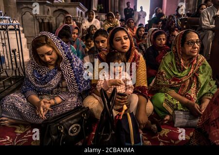 Les croyants chrétiens au cours de la lumière vendredi juste le service dans la Cathédrale du Sacré-Coeur à Lahore au Pakistan. En 2015, la paroisse a été attaqué dans la cathédrale au cours d'un attentat où de nombreuses victimes ont été signalés. Banque D'Images