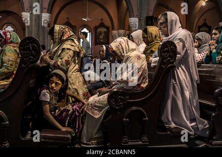 Les croyants chrétiens au cours de la lumière vendredi juste le service dans la Cathédrale du Sacré-Coeur à Lahore au Pakistan. En 2015, la paroisse a été attaqué dans la cathédrale au cours d'un attentat où de nombreuses victimes ont été signalés. Banque D'Images