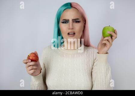 jeunes femmes aux cheveux teints de couleur bleue et rose et contenant des pommes vertes et rouges Banque D'Images