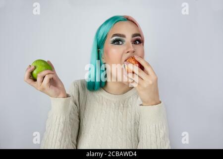 jeunes femmes aux cheveux teints de couleur bleue et rose et contenant des pommes vertes et rouges Banque D'Images