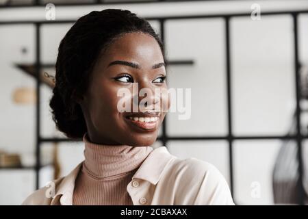 Image de l'incroyable heureux heureux optimiste jeune femme africaine posant intérieur à la maison Banque D'Images
