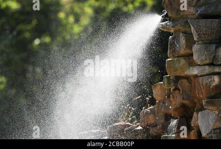 12 août 2020, Basse-Saxe, Osnabrück: Une douche d'eau est en opération dans une enceinte du zoo. Les animaux peuvent refroidir sous elle à des températures élevées. Photo: Friso Gentsch/dpa Banque D'Images