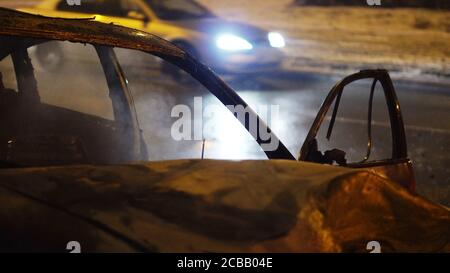 Côté d'une voiture brûlée après une collision lourde - rue d'hiver de Varsovie, Pologne. Photo de haute qualité Banque D'Images