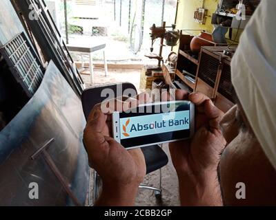 DISTRICT KATNI, INDE - 02 JUIN 2020 : un garçon indien tenant un smartphone avec le logo Absolut Bank à l'écran, l'éducation bancaire russe moderne Banque D'Images