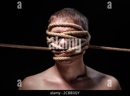 Photo de l'homme effrayant binded avec corde sur le visage