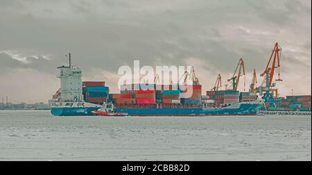 Un cargo avec des conteneurs près de la jetée du port maritime. Banque D'Images